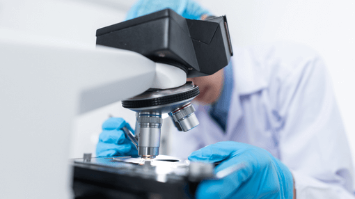 scientist looking at microscope