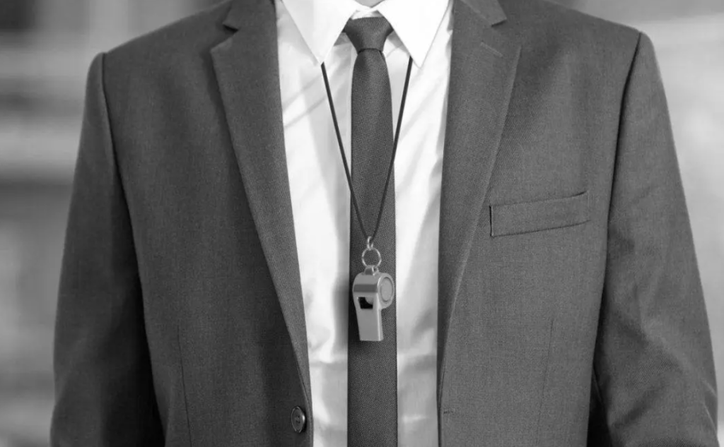 man in suit with whistle around neck